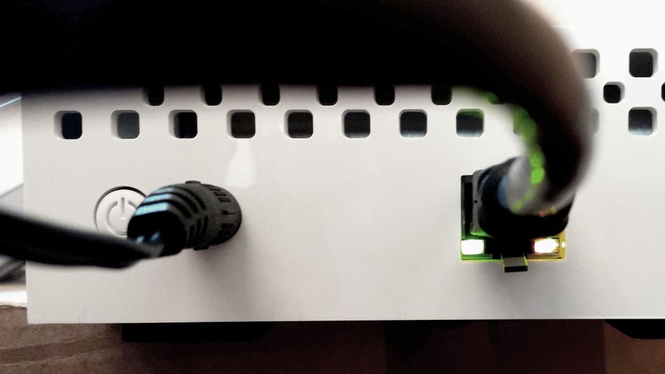 Das Bild zeigt eine NAS-Festplatte von nahe mit den zwei Anschlüssen, Netzstecker und Ethernet.