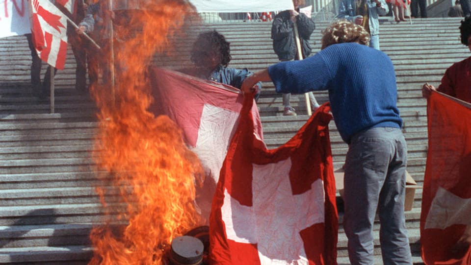 Wütende Aktivisten der jurassischen «Beliers» verbrennen vor dem Bundesgericht Schweizer Fahnen.