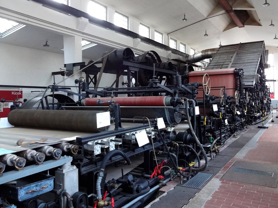 Papiermaschine in Fabrikhalle.