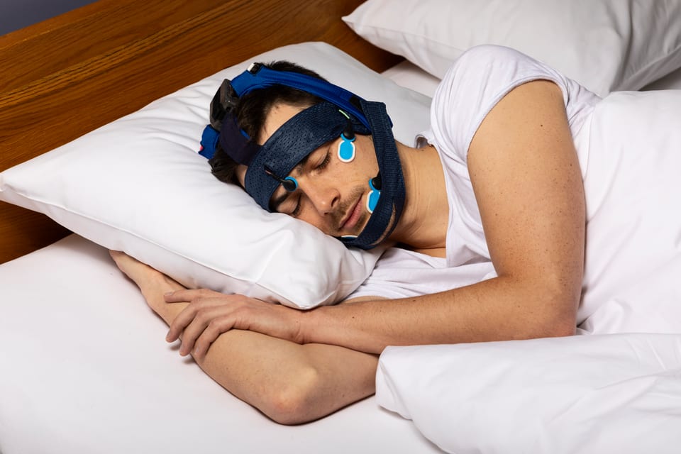 Ein Mann trägt das Sleeploop-System beim Schlafen.