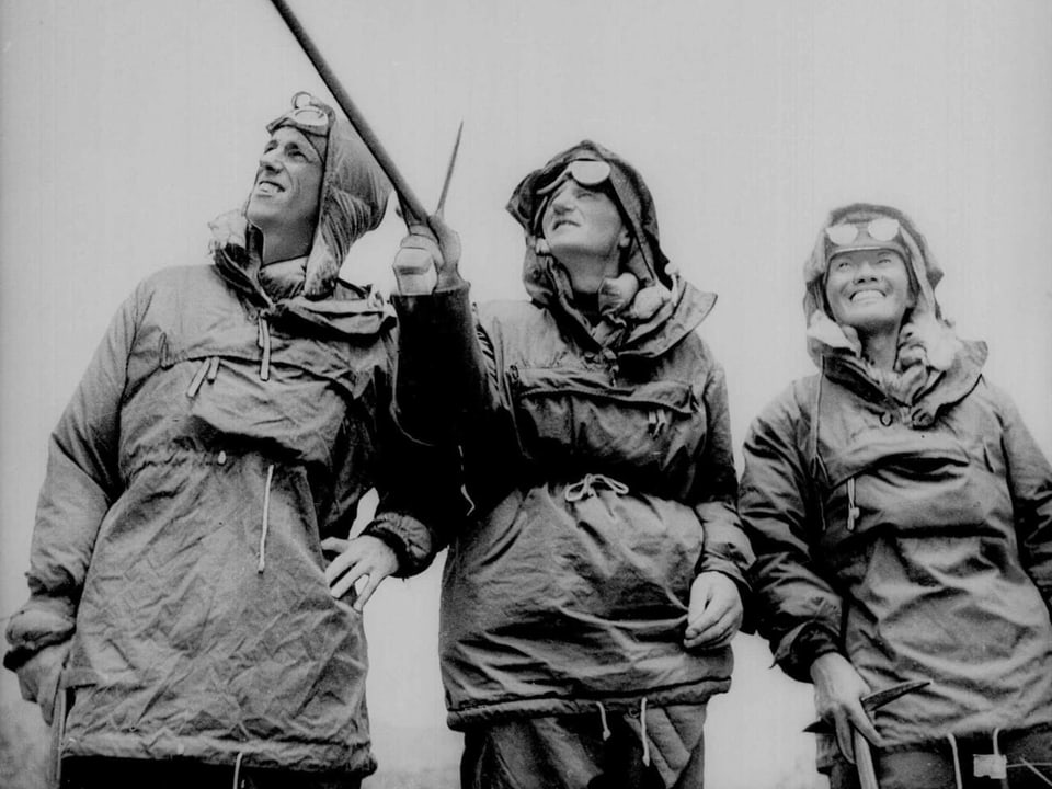 Drei Männer in Bergsteiger-Ausrüstung.