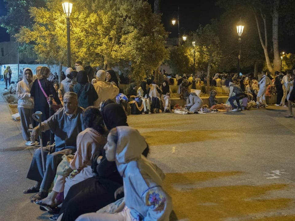 Menschen sitzen in Marokko nach einem Erdbeben in der Nacht auf der Strasse.