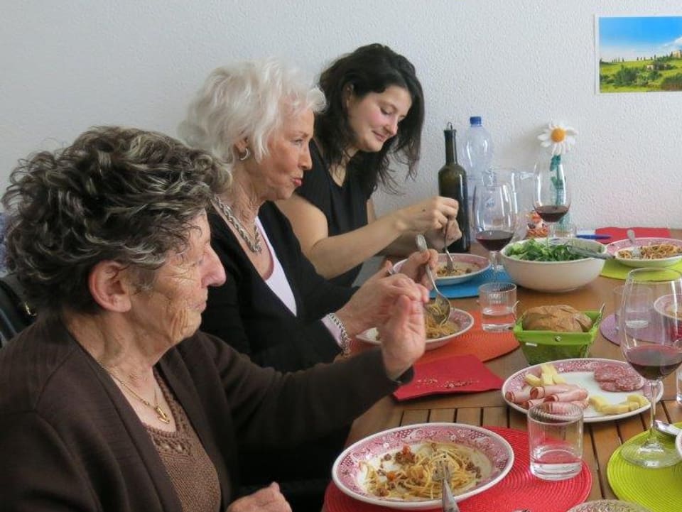 Drei Frauen beim Essen an einem Tisch.