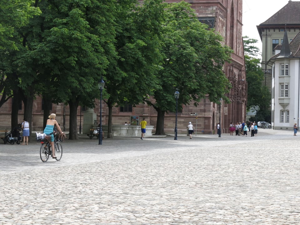 Frau auf dem Fahrrad fährt über den Münsterplatz