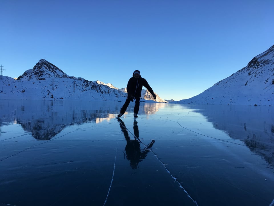 Eislaufen auf dem Lago Bianco (Berninapass) bei wolkenlosen Verhältnissen.