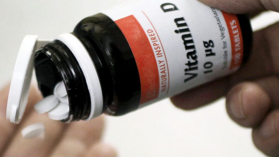 Vitamin-D-Tabletten werden aus einem Glasgefäss in die Hand geschüttet.