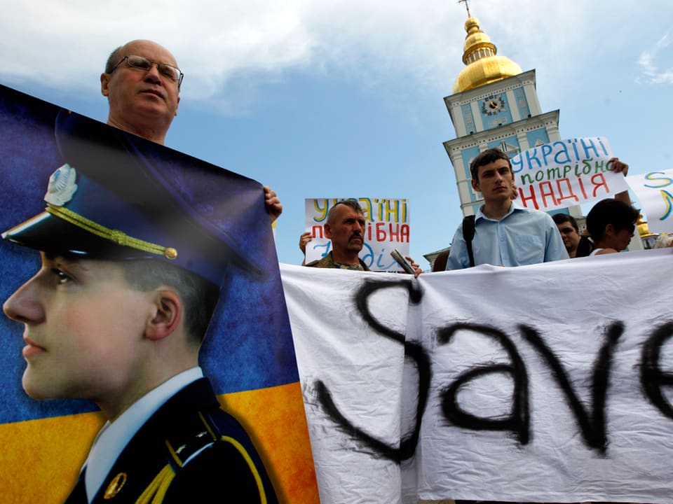 Aktivisten halten Transparente mit dem Foto von Sawtschenko