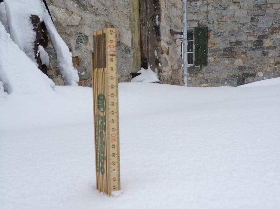 Ein Massstab misst 23 Zentimeter Schnee.