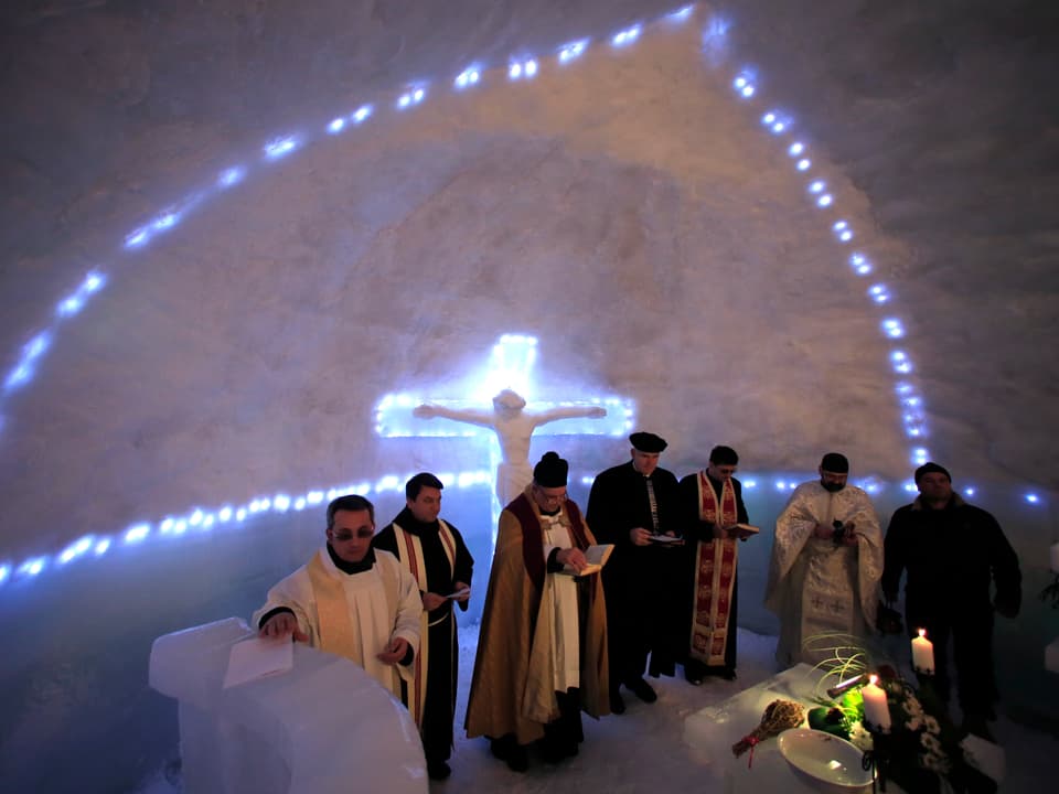 Ein Gottesdienst mit mehreren Geistlichen in einer Kirche aus Eis in Rumäniens Bergen.