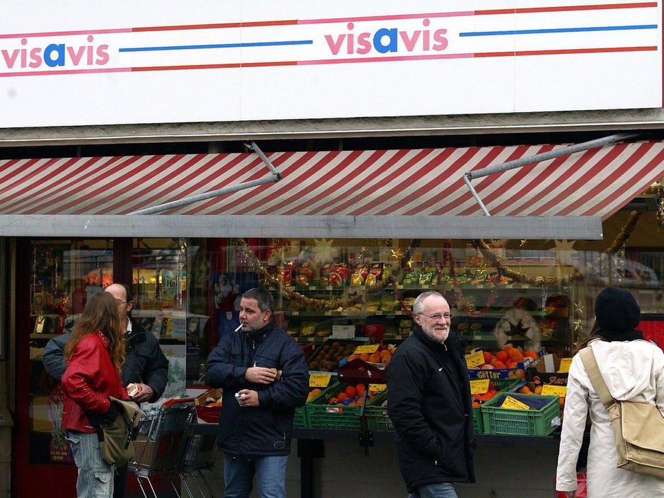Personen vor einem Visavis-Laden.