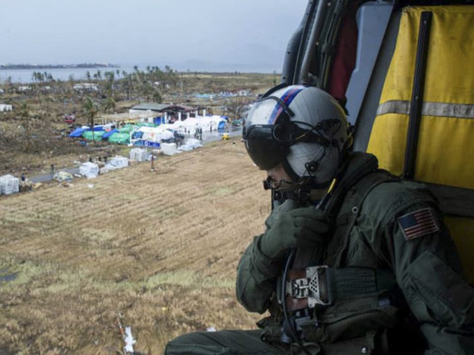 Ein Soldat liefert mit einem US-Helikopter Esspakete sowie Wasserflaschen zum Flughafen Tacloban. 