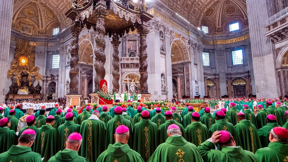 Innenraum des Petersdoms mit grossem Altar, davor hunderte Männer in grünen Ordensgewändern