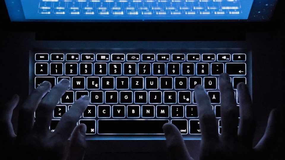 Symbolbild: Hände auf Tastatur im Dunkeln.