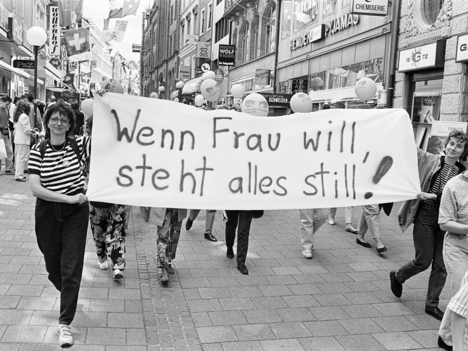 Frauen mit Transparent «Wenn Frau will, steht alles still».