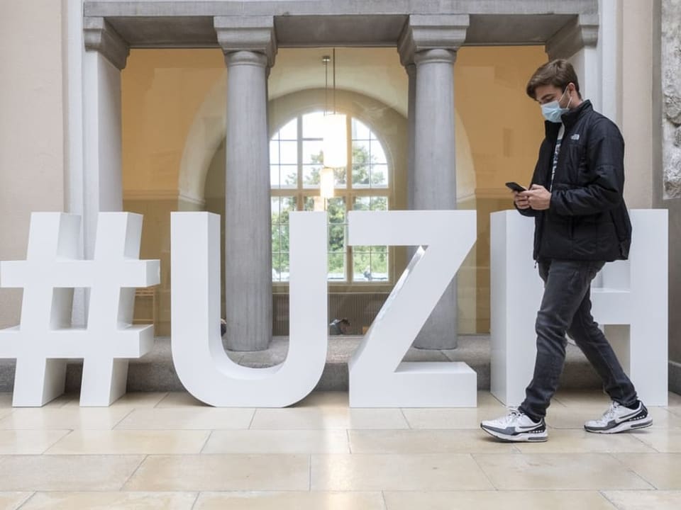 Student läuft im Lichthof der Universität Zürich.