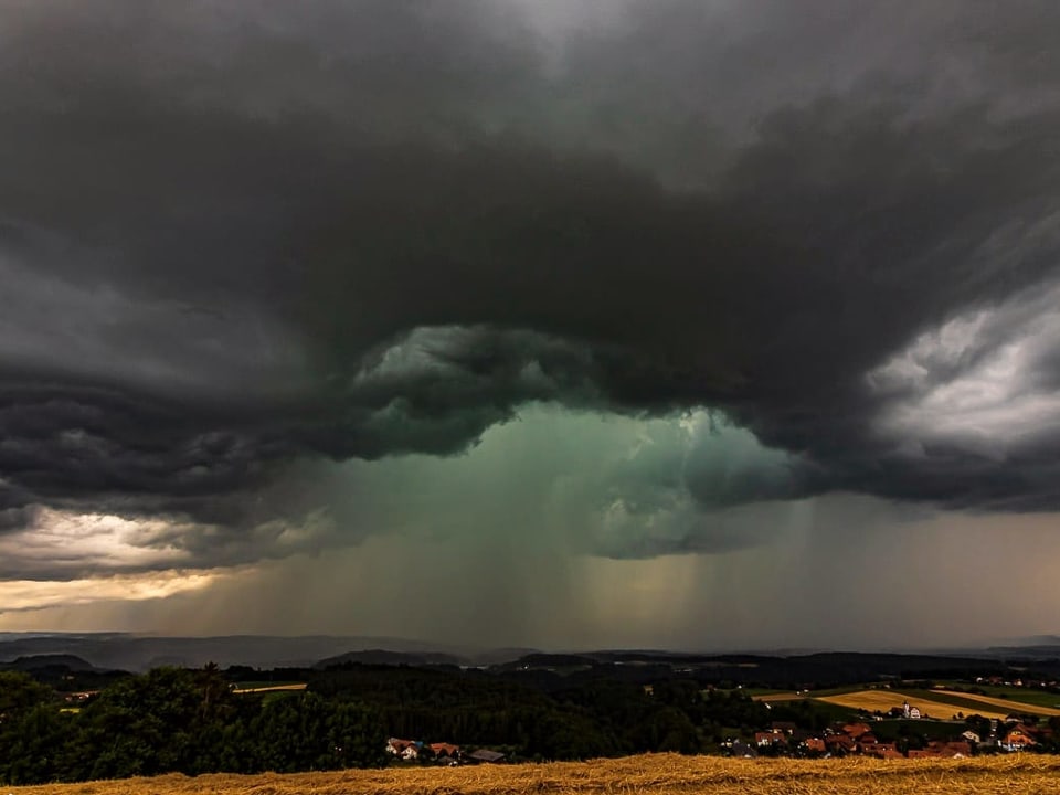 27. Juli Dunkle Gewitterwolken mit Platzregen im Hintergrund.