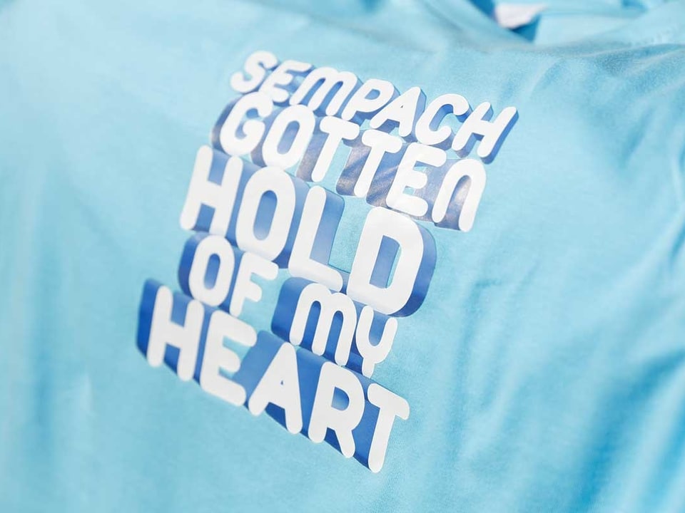 Auf einem hellblauen T-Shirt steht: Sempach gotten hold of my heart.