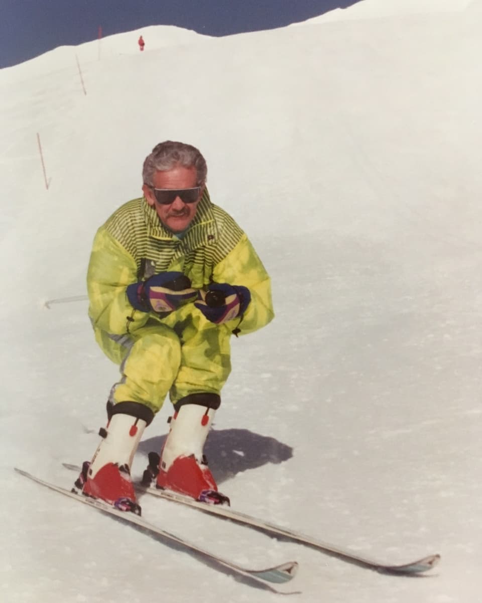 Ein Mann im knallgelben Skidress auf der Piste.