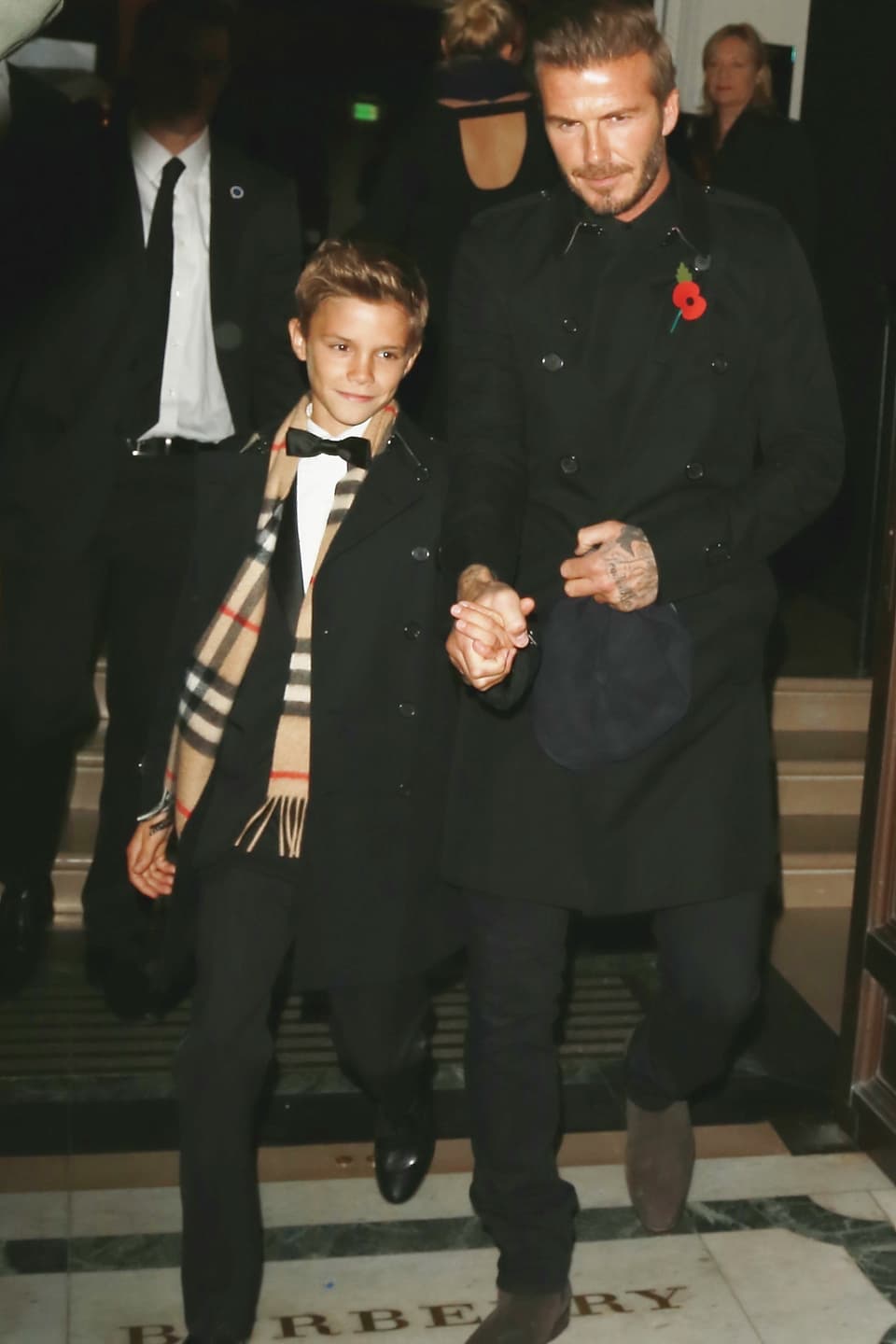 Romeo Beckham an der Hand von David Beckham.
