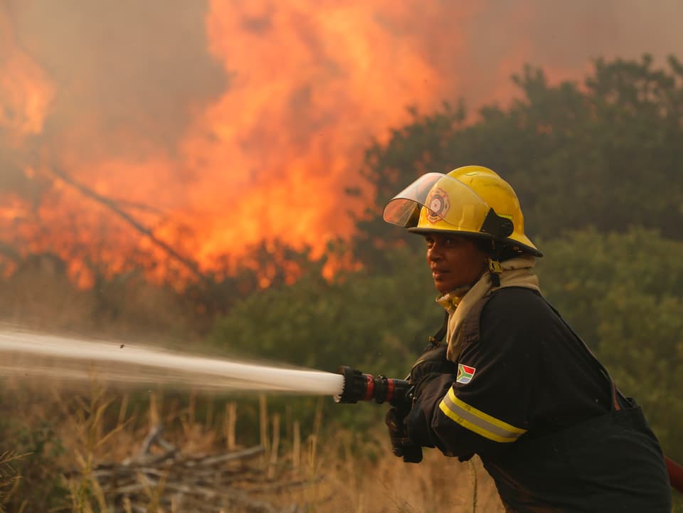 Ein Feuerwehrmann kämpft gegen die Flammen. 