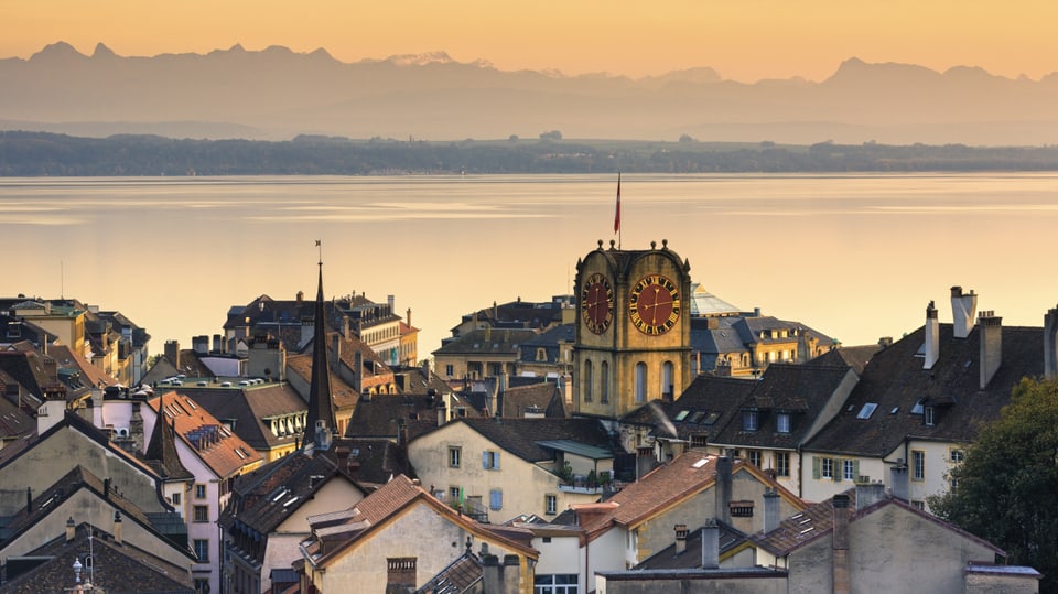 Die Stadt Neuchâtel, dahinter der See im Abendrot.