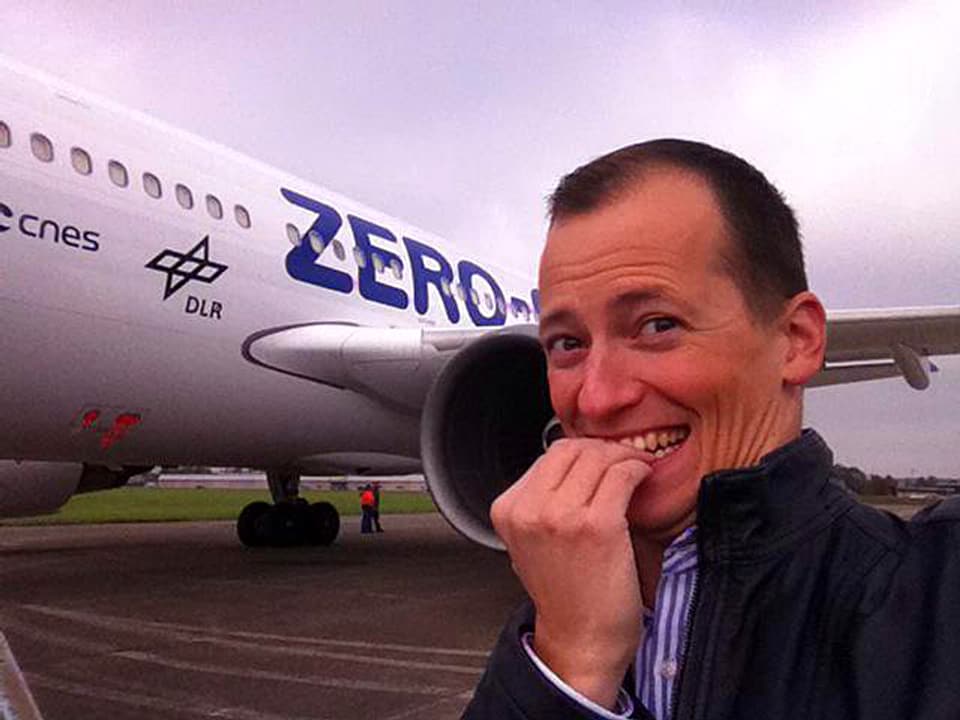 Michael Weinmann vor einem Flugzeug, er wirkt nervös