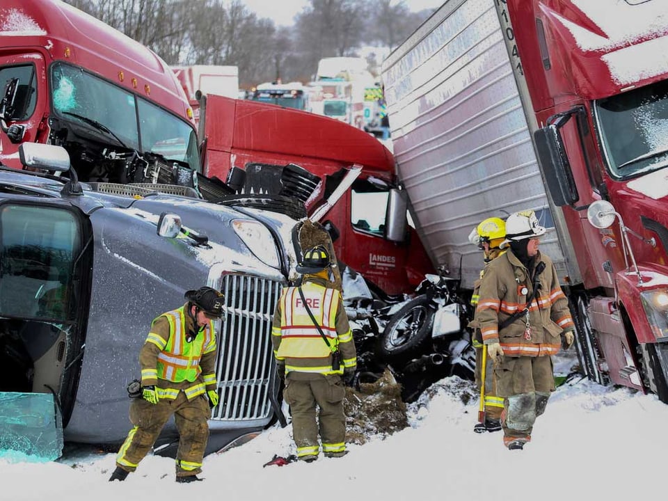 Rettungskräfte vor zerstörten Lastwagen