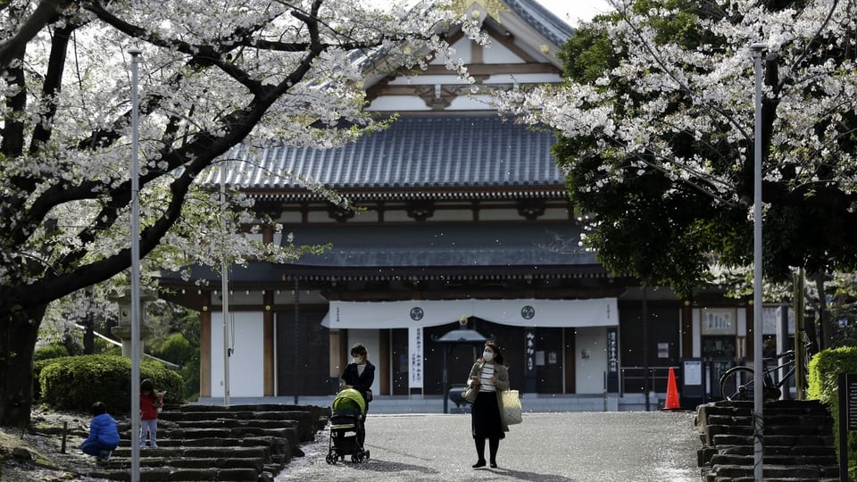Japanischer Tempel. Menschen mit Maske. Blühende Bäume.