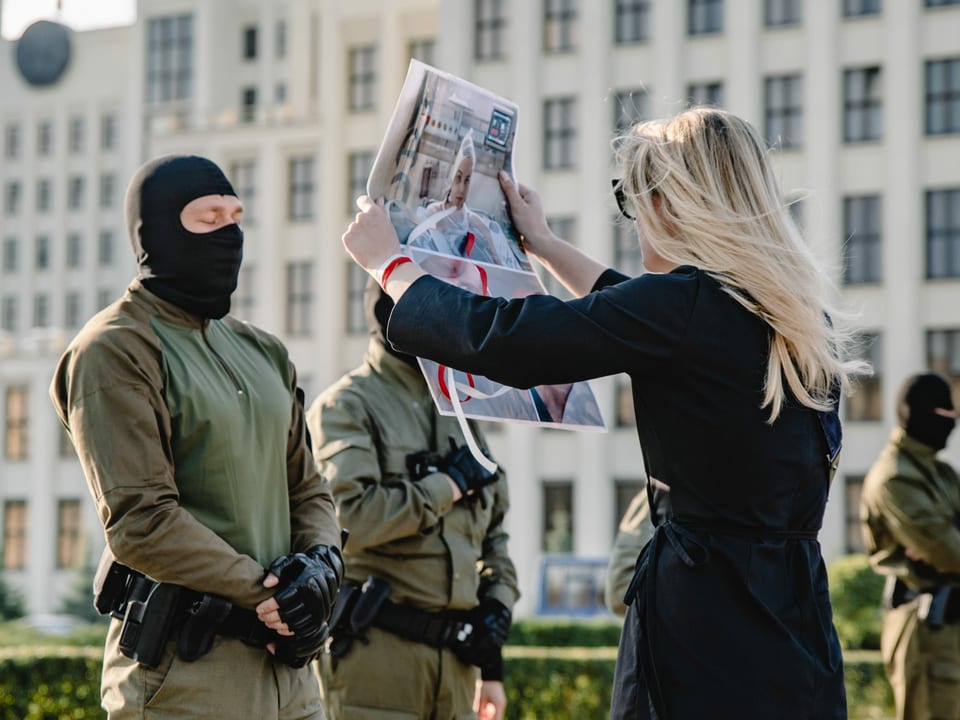 Eine Frau hält einem Soldaten ein Plakat vor das Gesicht.