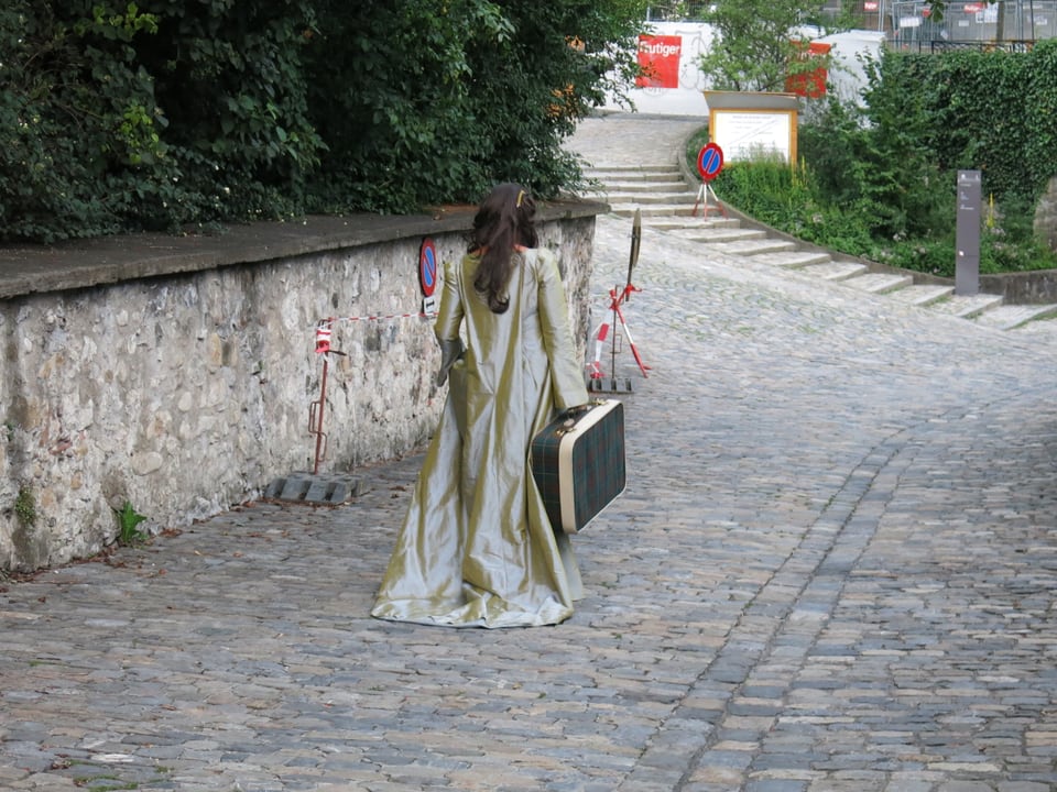 Eine elegant gekleidete Frau mit einem Koffer läuft weg.