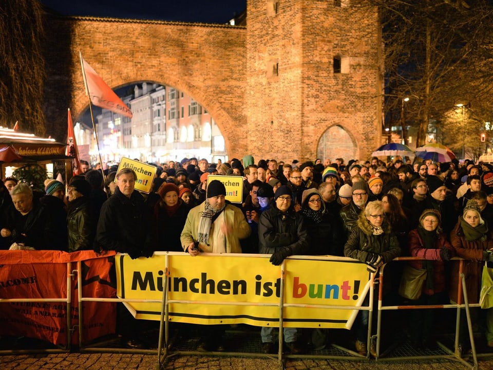 Zahlreiche Menschen versammeln sich hinter einem Transparent mit der Aufschrift «München ist bunt»
