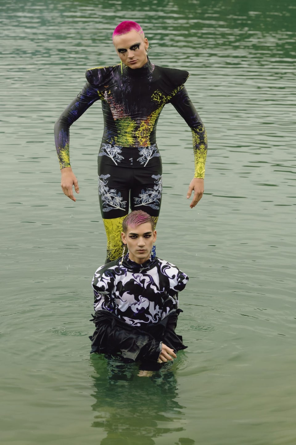 Zwei Menschen mit bunten Haaren im Wasser.