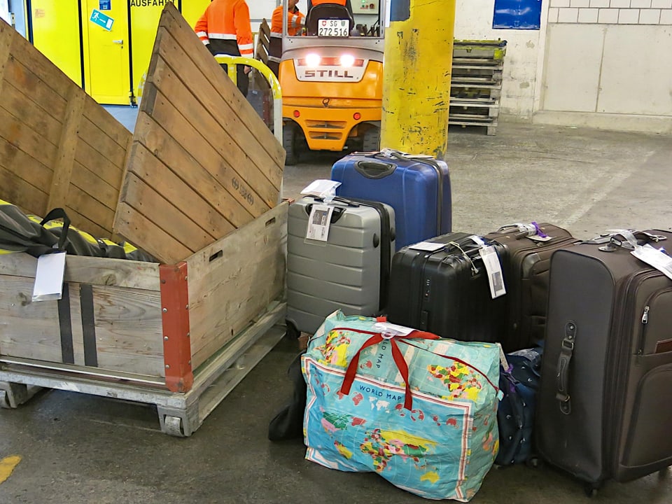 Koffern und Reisetaschen stehen in einem Gepäckraum beim Bahnhof am Boden.