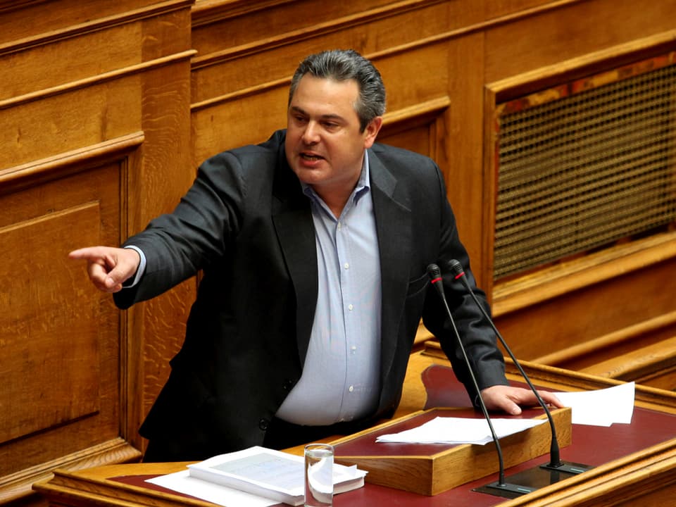 Am Rednerpult im griechischen Parlament zeigt Kammenos mit ausgestrecktem Arm nach rechts.