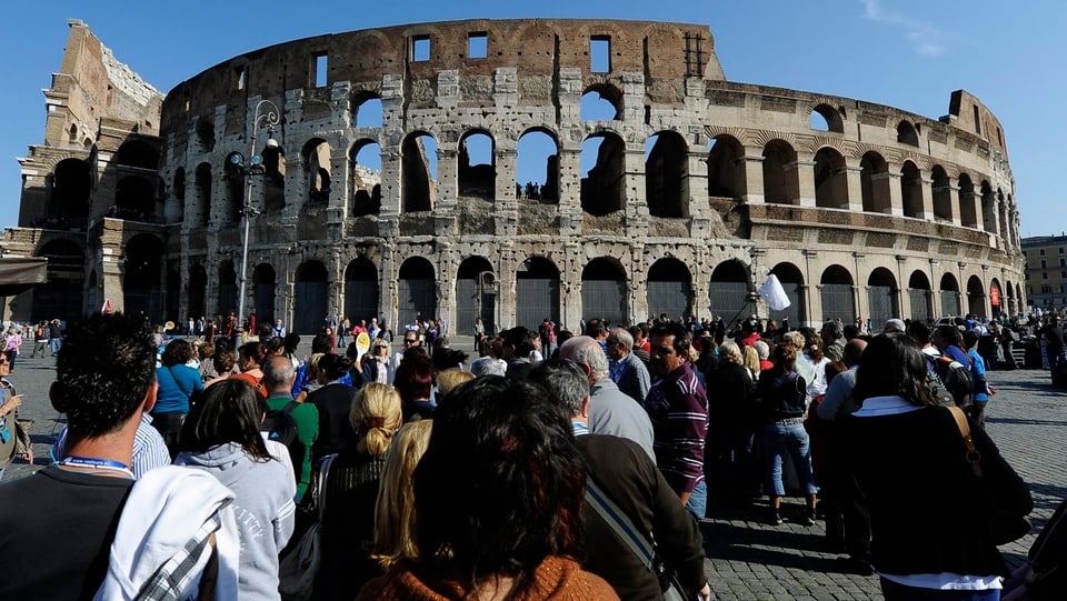 Vor dem Kolosseum in Rom stehen Touristen an.