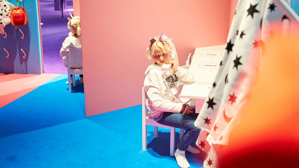 Mädchen sitzt am Telefon in einem rosa zimmer