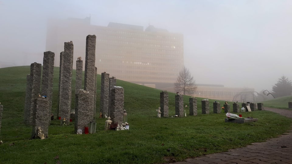 Der Park vor dem Kantonsspital. Zu sehen sind Säulen aus Stein mit Kerzen und Andenken an verstorbene Kinder. 