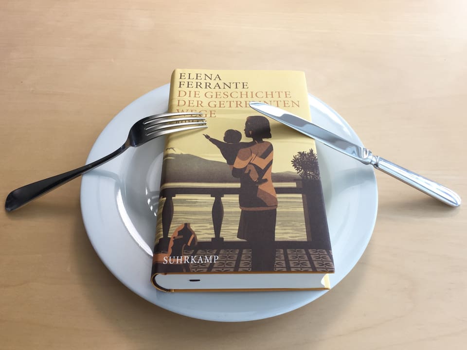 Der Roman «Die Geschichte der getrennten Wege» von Elena Ferrante liegt auf einem Teller