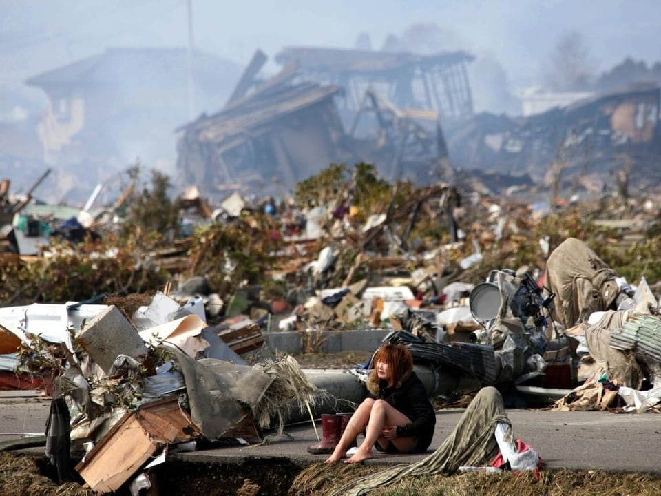 Frau umgeben von Trümmern