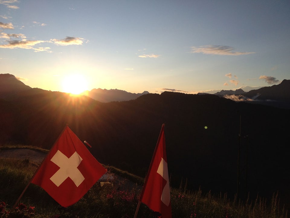 Auf der Belalp bei Sonnenuntergang, im Vordergrund zwei Schweizerfahnen.