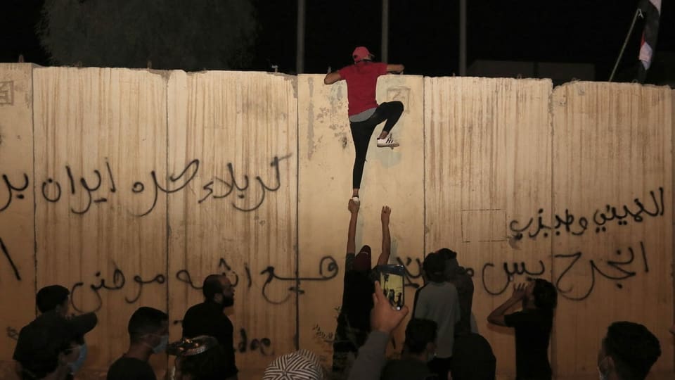Jemand klettert auf die Mauer um das iranische Konsulat in Kerbela.