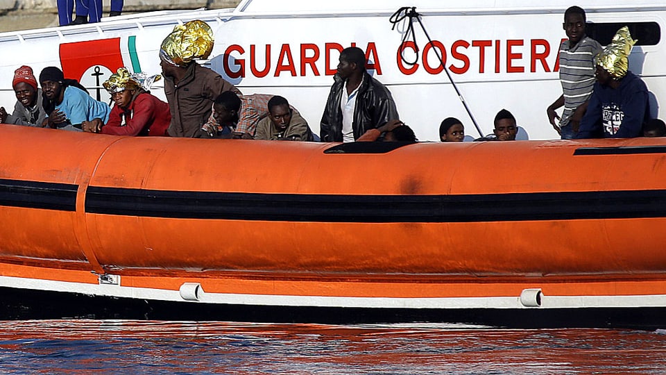 Marodes Gummischlauchboot mit vielen afrikanischen Passagieren.