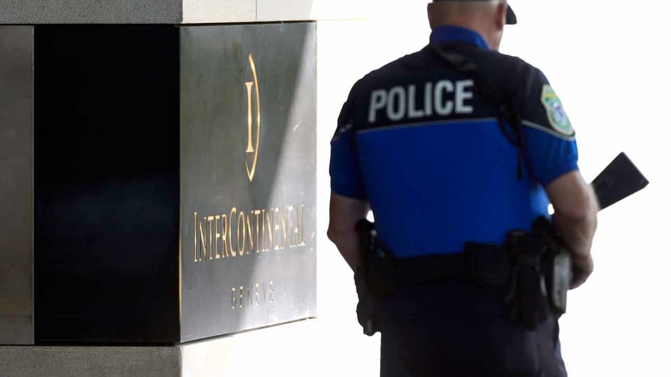 Ein Polizist steht vor einem Genfer Hotel, in dem die Gespräche stattgefunden haben.