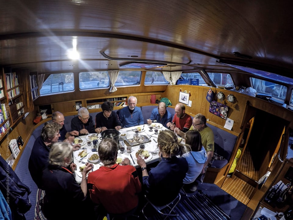 Die Crew im Bauch des Schiffs beim Abendessen