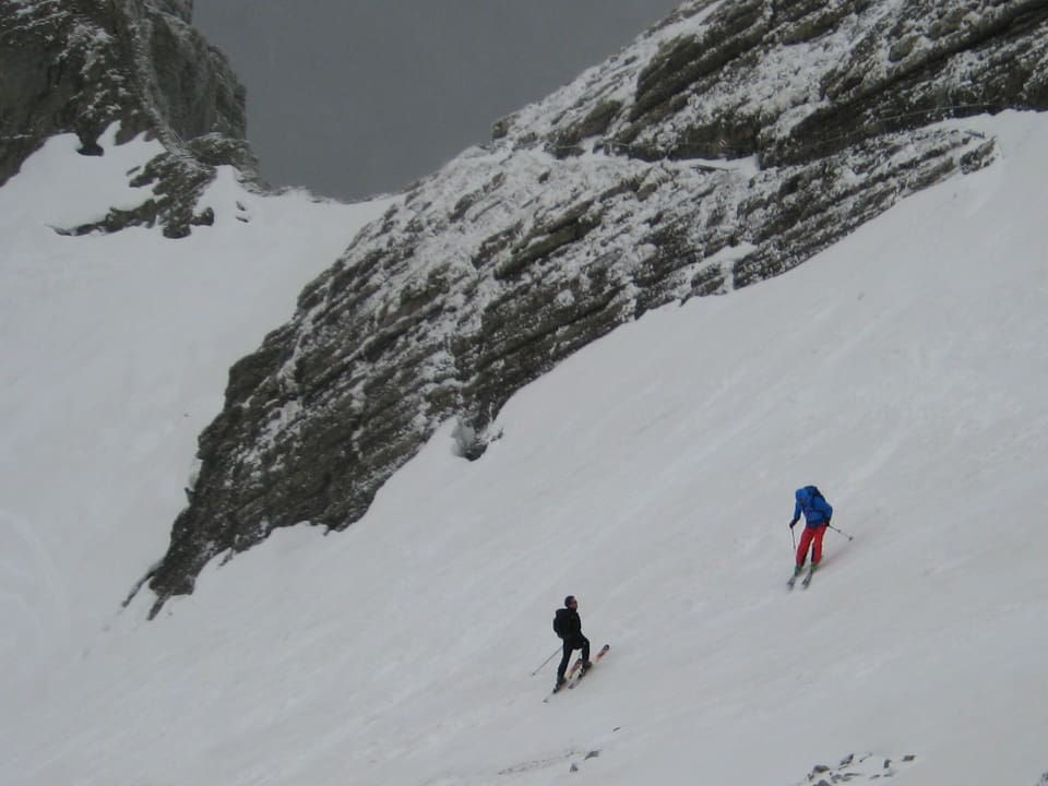Zwei Skifahrer im verschneiten Gebirge. 