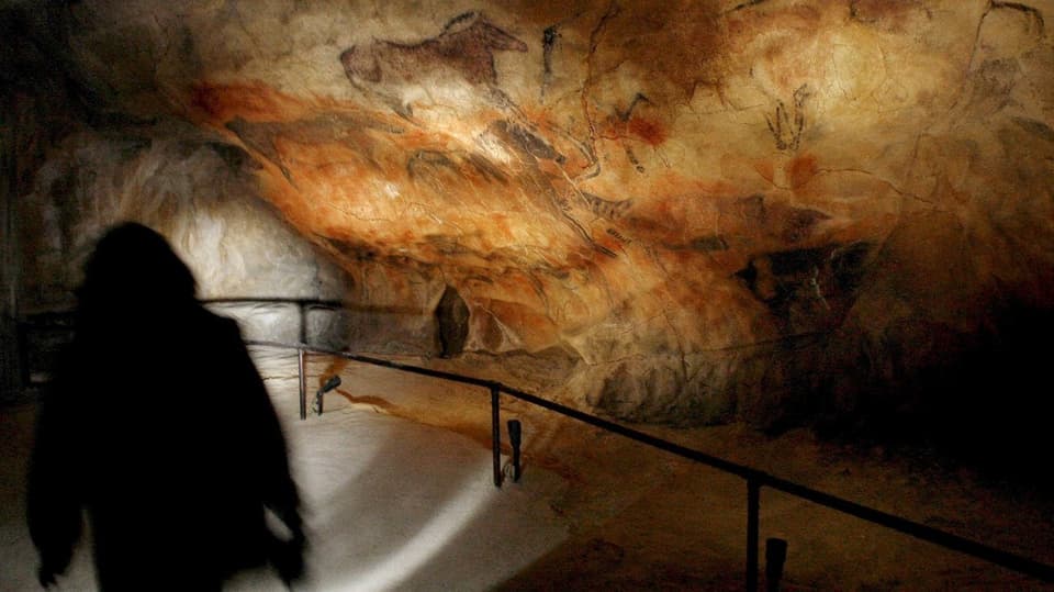 Schatten geht der Höhlenwand entlang, Malereien auf dem Fels.