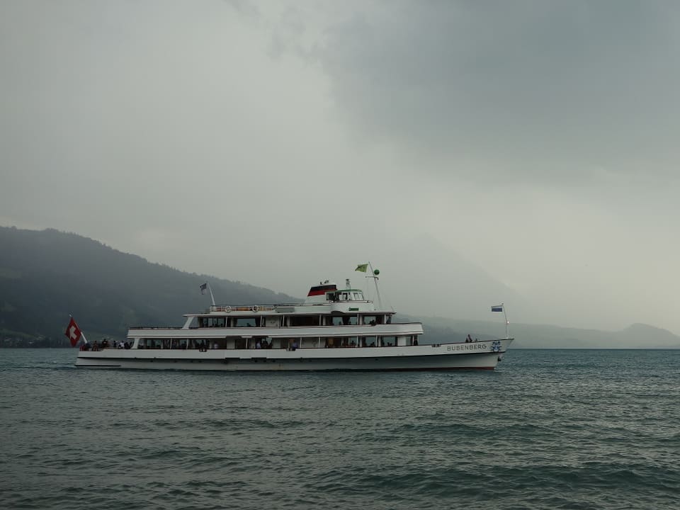 Schiff auf einem grauen See bei trübem Wetter mit Regen. 