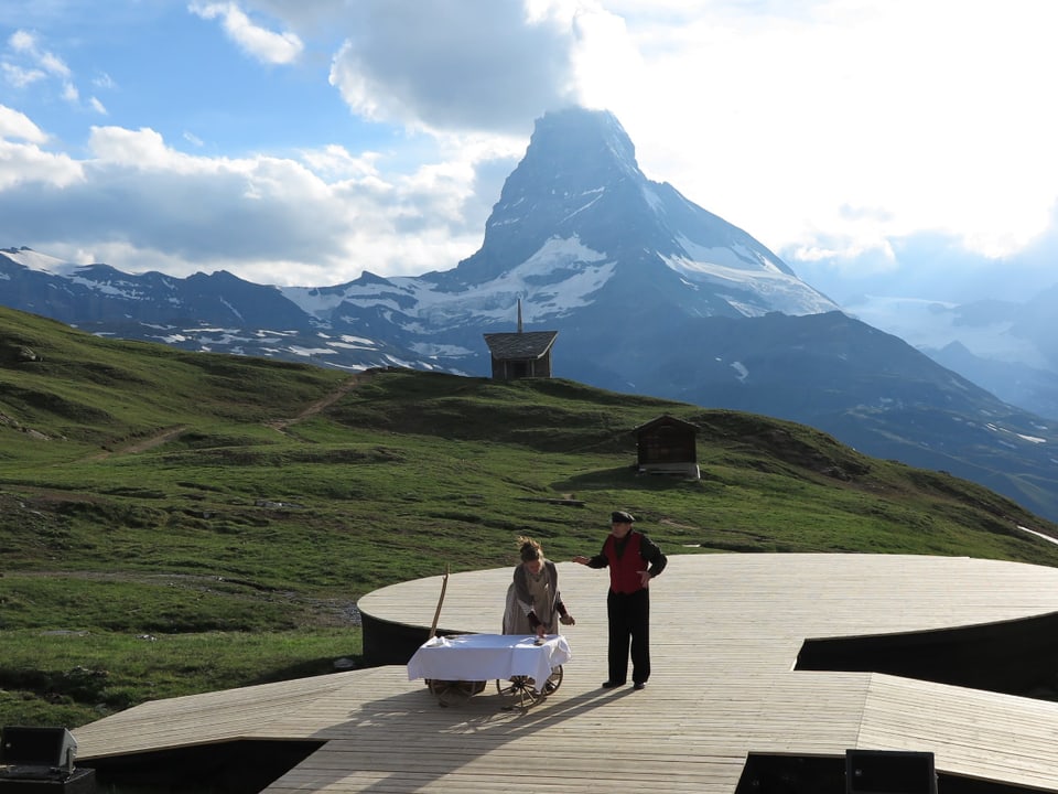 Holzbühne mit zwei Schauspielern vor dem Matterhorn.