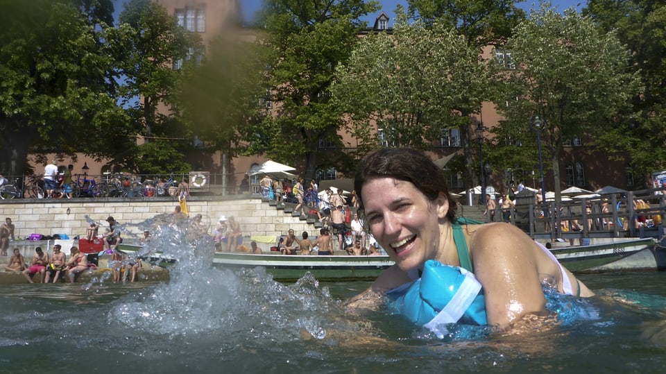 Frau schwimmt im Rhein