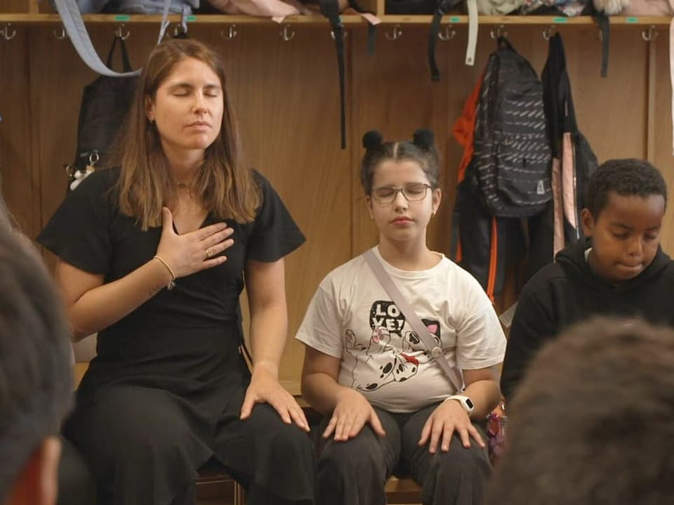 In the picture you can see children and the teacher in a circle.
